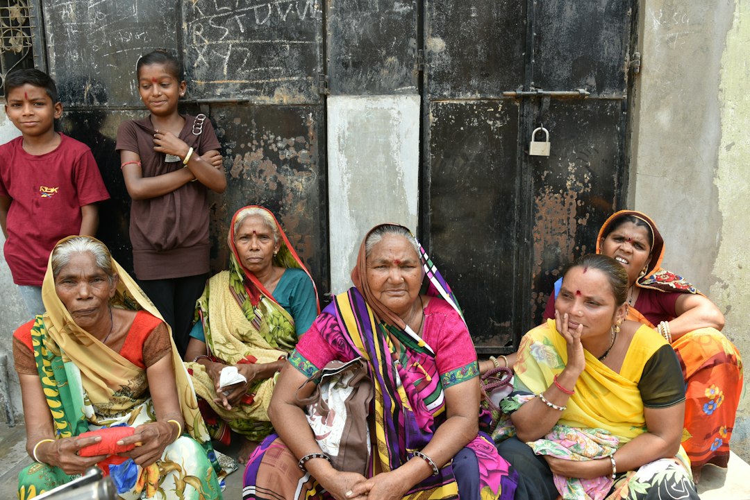 Women in colourful sarees sitting together in a village community